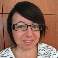 profile picture of Amanda Copeland round face with dark hair hair swept across face wide brim glasses and teeth showing smile